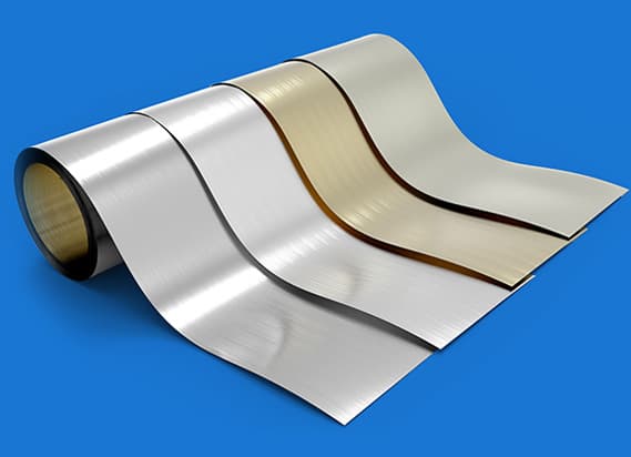 Rollen von Metallstreifen in verschiedenen Oberflächen und Farben, symbolisierend Metallverarbeitung und Materialvielfalt in der Produktion von Stanz- und Ziehteilen.